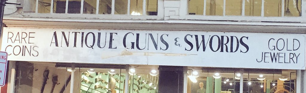 shop sign advertising antique guns, swords... and gold jewelry
