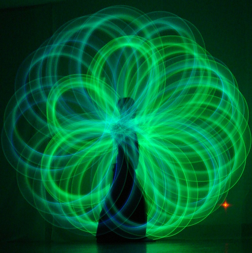 green poi circles, in a beautiful light pattern, around a woman